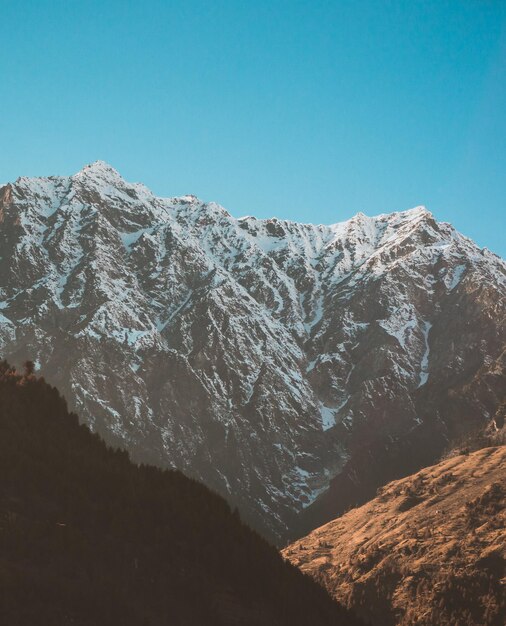 Foto vista panorâmica de montanhas cobertas de neve contra um céu azul claro