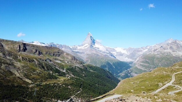 Foto vista panorâmica de montanhas cobertas de neve contra um céu azul claro