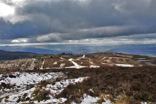 Vista panorâmica de montanhas cobertas de neve contra um céu nublado