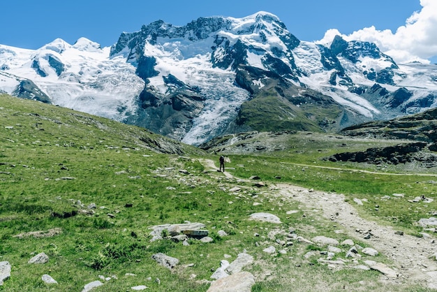 Vista panorâmica de montanhas cobertas de neve por campo contra o céu