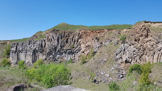 Vista panorâmica de montanhas rochosas contra um céu azul claro