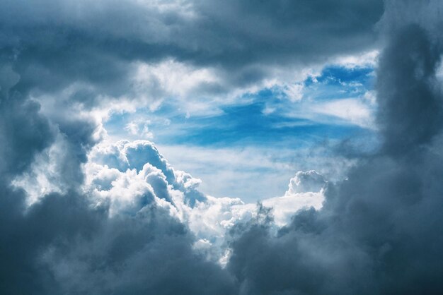 Vista panorâmica de nuvens escuras tempestuosas e lacuna de nuvens com fundo de céu azul