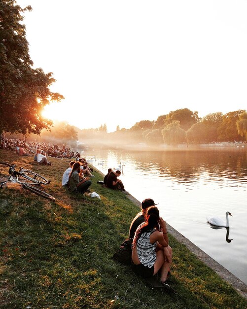 Foto vista panorâmica de pessoas sentadas ao lado do lago no parque