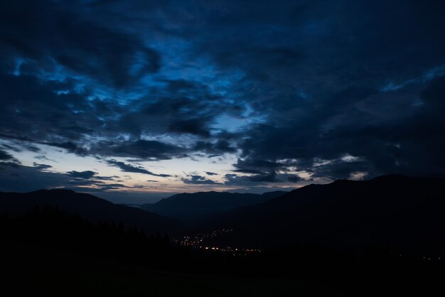 Vista panorâmica de silhuetas de montanhas contra o céu dramático