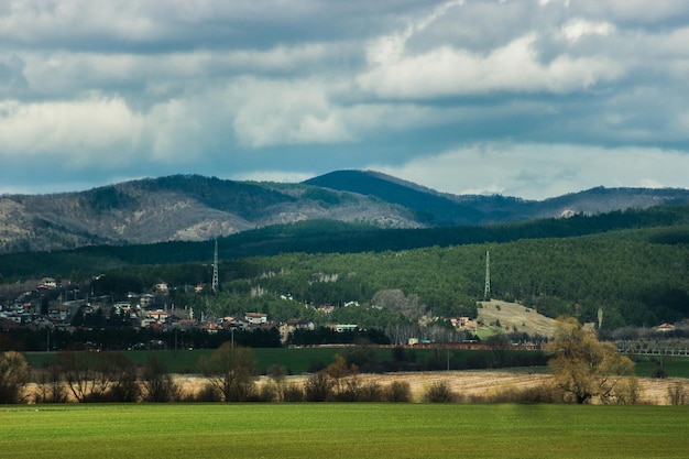 Vista panorâmica de um campo agrícola por montanhas contra o céu