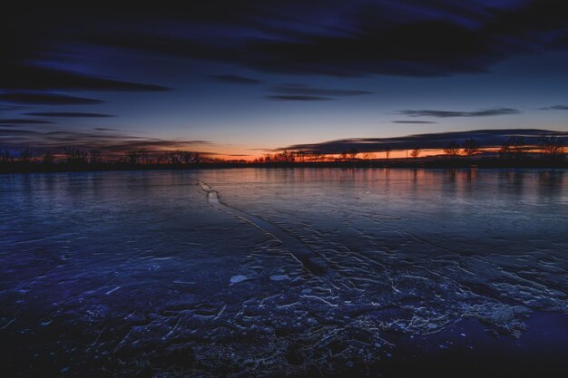 Foto vista panorâmica de um lago congelado contra o céu durante o pôr-do-sol