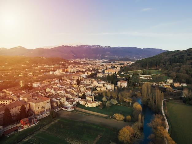 Vista panorâmica de um prado verde, edifícios com montanhas nevadas