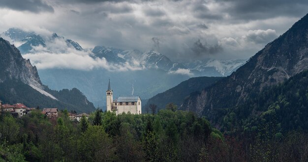 Foto vista panorâmica de uma paisagem temperamental com uma pequena igreja nas montanhas dos dolomitas belluno veneto itália