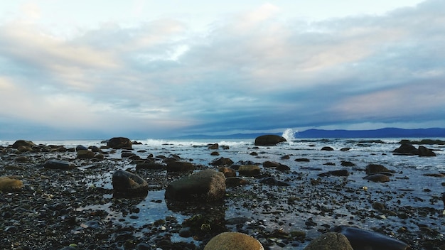 Vista panorâmica de uma praia rochosa contra um céu nublado