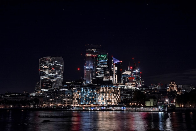 Vista panorámica del distrito financiero de Londres con muchos rascacielos en el centro de Londres por la noche.