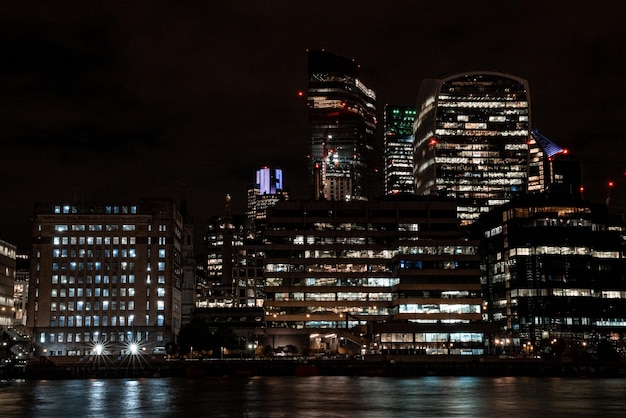 Vista panorámica del distrito financiero de Londres con muchos rascacielos en el centro de Londres por la noche.