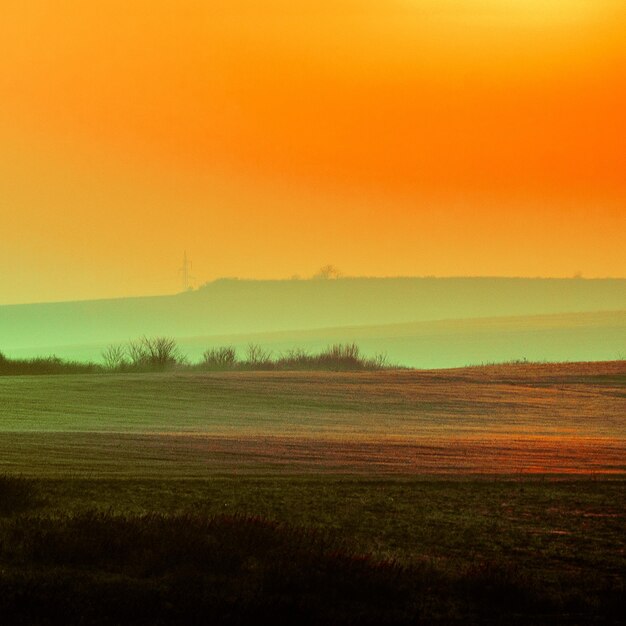 Foto vista panorâmica do campo contra o céu durante o pôr-do-sol