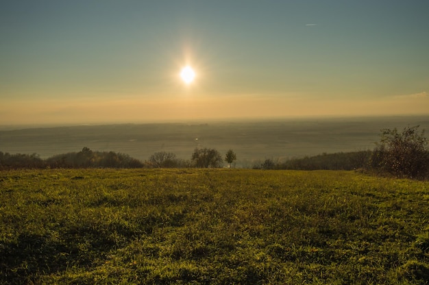 Foto vista panorâmica do campo contra o céu durante o pôr-do-sol