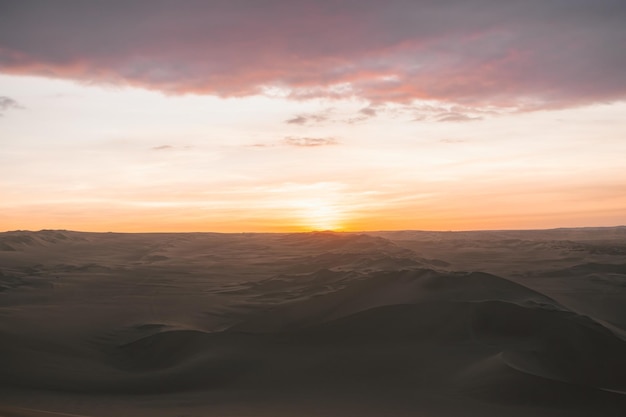 Vista panorâmica do deserto contra o céu durante o pôr-do-sol