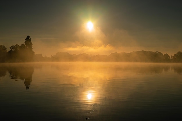 Foto vista panorâmica do lago contra o céu durante o pôr-do-sol nebuloso