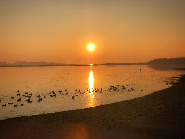 Vista panorâmica do lago contra o céu laranja