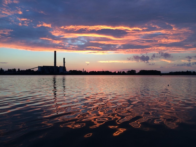 Vista panorâmica do lago contra o céu nublado durante o pôr do sol