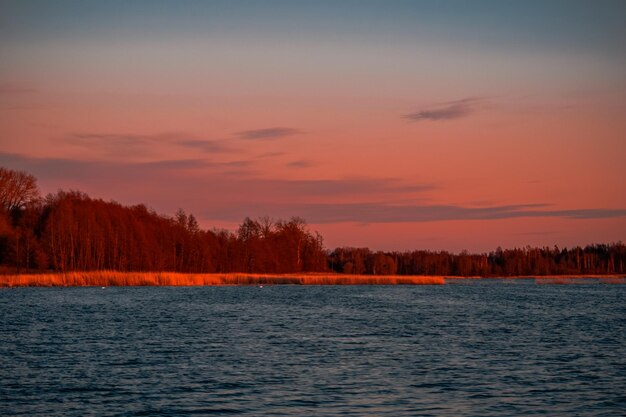 Foto vista panorâmica do lago contra o céu romântico ao pôr-do-sol