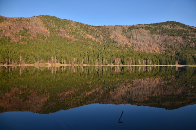 Foto vista panorâmica do lago pelas montanhas contra o céu claro
