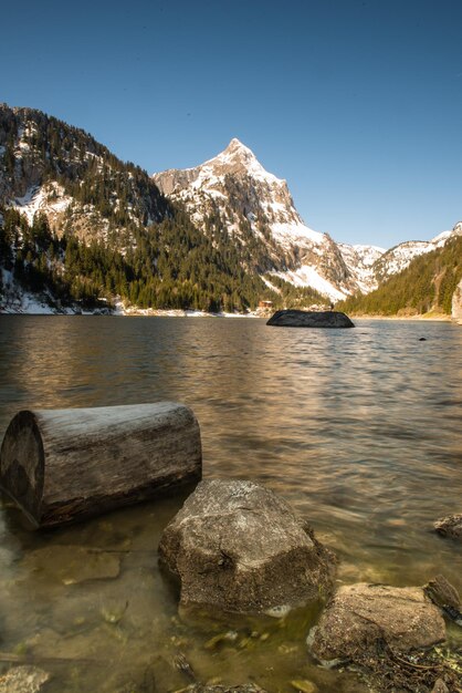 Foto vista panorâmica do lago pelas montanhas contra o céu claro