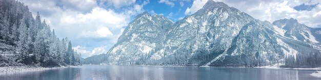 Foto vista panorâmica do lago por montanhas cobertas de neve contra o céu