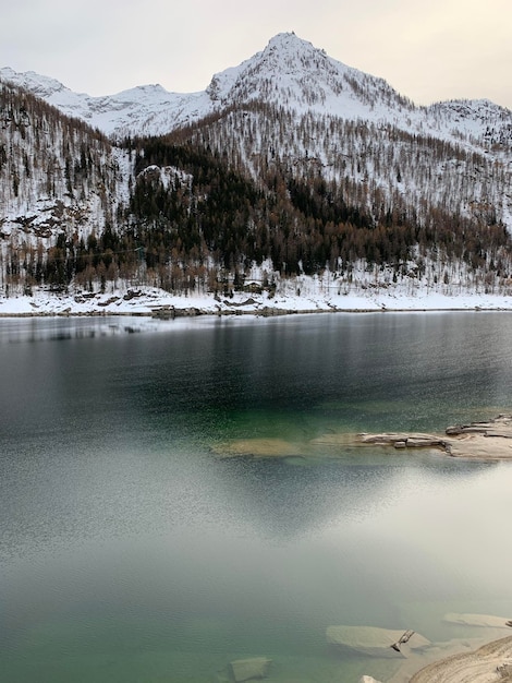 Foto vista panorâmica do lago por montanhas cobertas de neve contra o céu