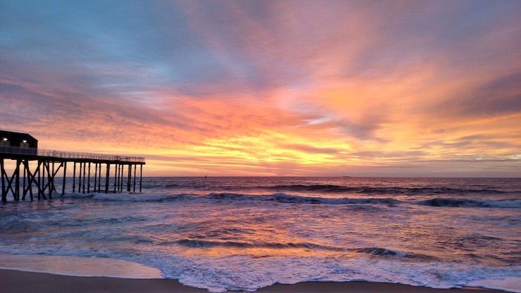 Foto vista panorâmica do mar contra o céu dramático durante o pôr-do-sol