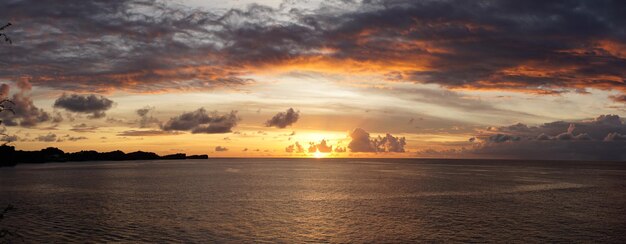 Vista panorâmica do mar contra o céu dramático durante o pôr-do-sol