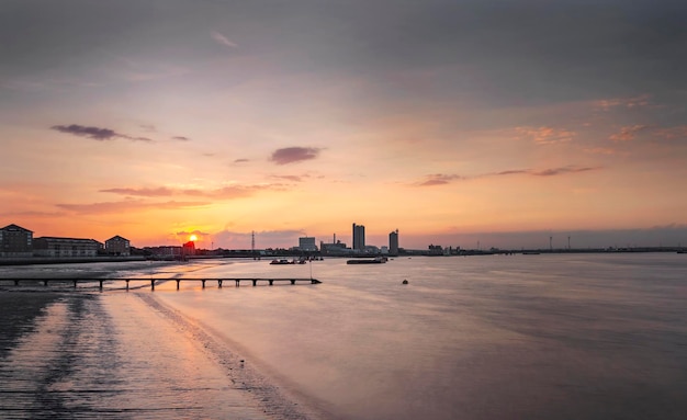 Vista panorâmica do mar por edifícios contra o céu durante o pôr-do-sol