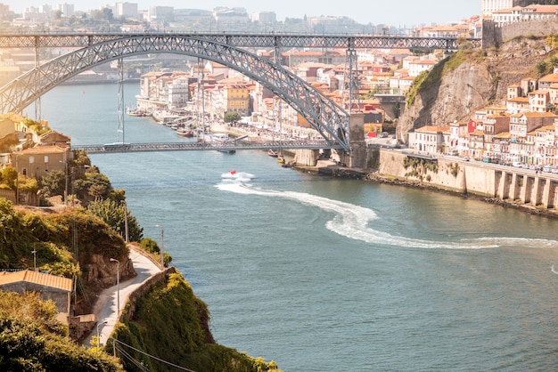 Foto vista panorâmica do rio douro com flutuadores de lancha e uma bela ponte de ferro na cidade do porto, portugal