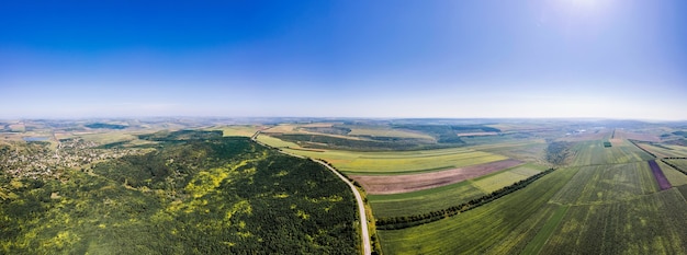 Vista panorámica de drones aéreos de la naturaleza en Moldavia. Carretera, amplios campos, pueblo, bosque