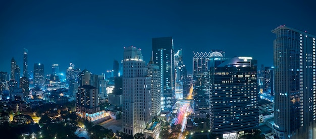 Vista panorámica de la escena nocturna del paisaje urbano de Bangkok con un moderno edificio de oficinas.