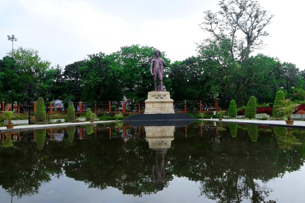 Vista panorámica de la estatua de bisra munda en forma de agua con fondo de árbol verde