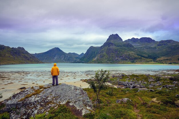 Vista panorámica del fiordo Un joven se para en una roca Hermoso paisaje de montaña Desierto escandinavo Naturaleza de Noruega