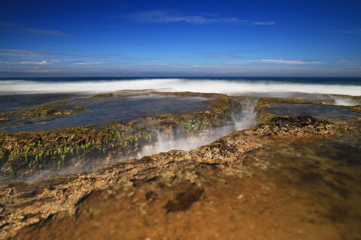 Foto vista panorámica de la formación rocosa en la playa con cielo azul