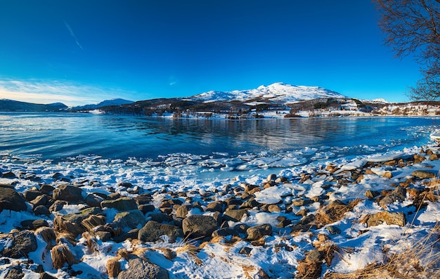 Vista panorámica del hermoso lago invernal con montañas nevadas en las islas Lofoten en el norte de Noruega