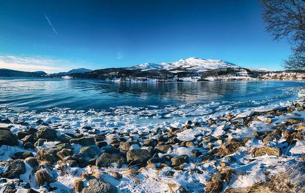 Vista panorámica del hermoso lago de invierno con montañas nevadas en las islas Lofoten en el norte de Noruega