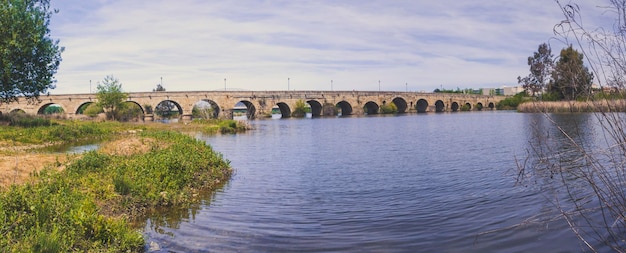 Foto vista panorámica del histórico puente romano sobre el río guadiana en mérida, españa