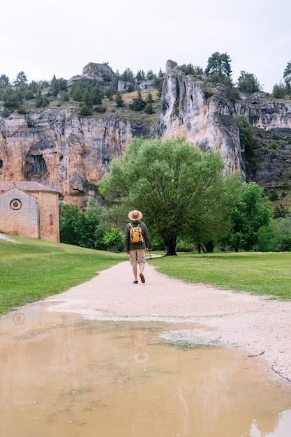 Vista panorámica del hombre irreconocible caminando aislado en la naturaleza con mochila. Vista vertical del hombre viajando solo en el cañón del río Lobos en Soria. Personas y destinos de viaje en España.