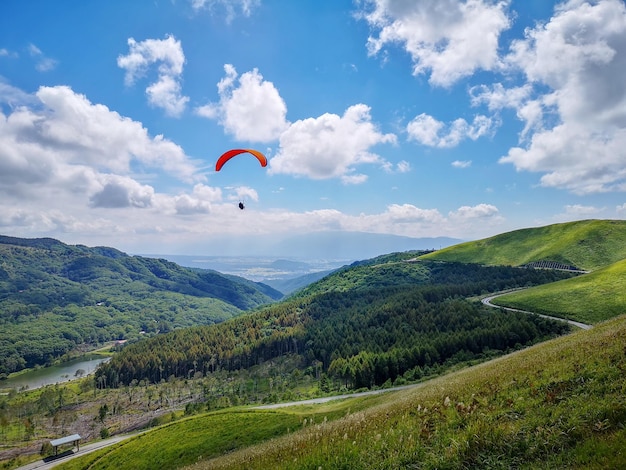 Foto vista panorámica de un hombre en parapente sobre el campo contra el cielo