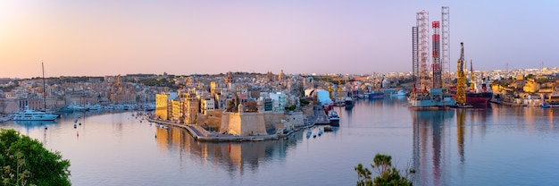 Vista panorámica del horizonte de las antiguas defensas de Valletta, el Gran Puerto y Tres ciudades, tres ciudades fortificadas de Birgu, Senglea y Cospicua, al amanecer, Valletta, Malta.