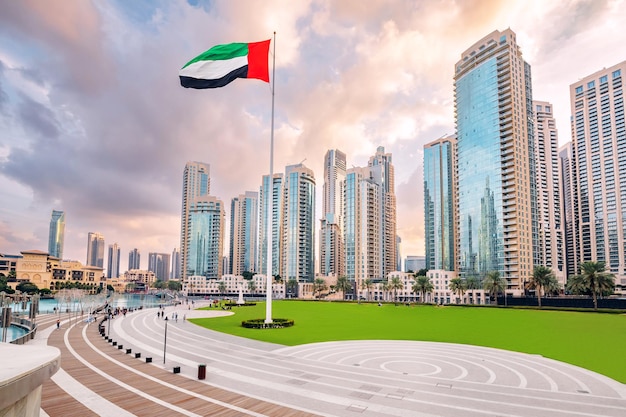 Vista panorámica del horizonte de Dubai con los rascacielos y la bandera nacional Sightseeing y destinos de viaje en los Emiratos Árabes