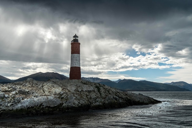 Vista panorámica de la isla rocosa donde se encuentra el faro de Les Eclaireurs bajo un cielo nublado