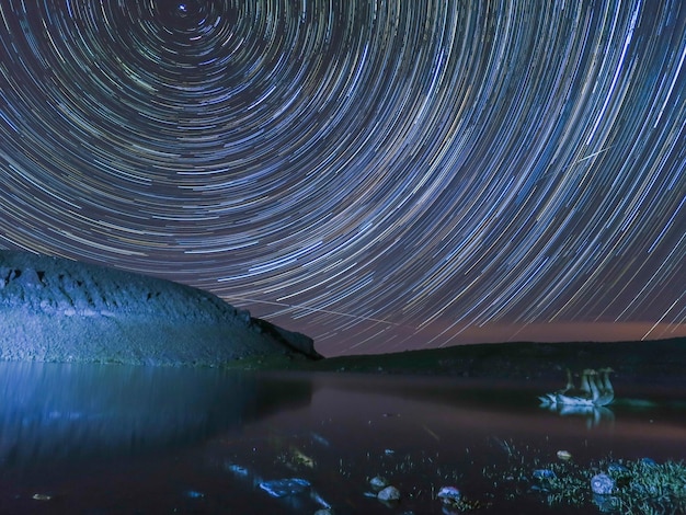 Vista panorámica del lago contra los senderos iluminados por las estrellas