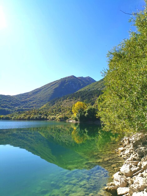 Foto vista panorámica del lago y las montañas contra un cielo azul claro