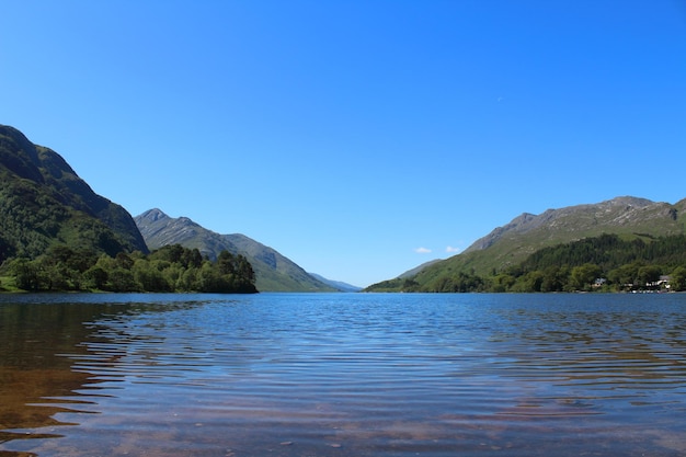 Foto vista panorámica del lago y las montañas contra un cielo azul claro