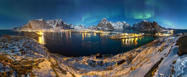 Vista panorámica del lago por las montañas cubiertas de nieve contra el cielo de noche