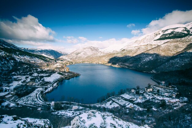 Vista panorámica del lago y las montañas cubiertas de nieve contra el cielo