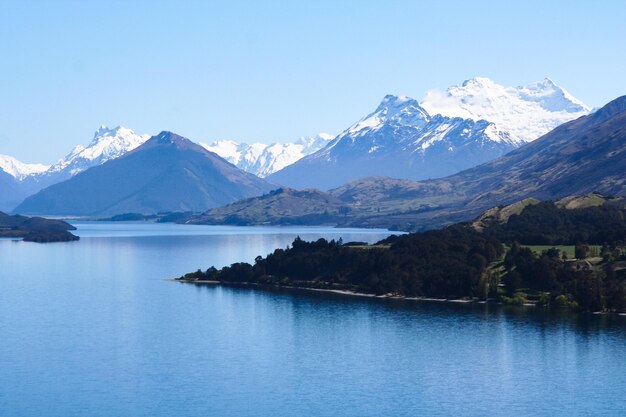 Foto vista panorámica del lago y las montañas cubiertas de nieve contra el cielo