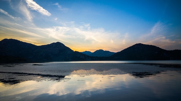 Vista panorámica del lago y las montañas durante la puesta de sol